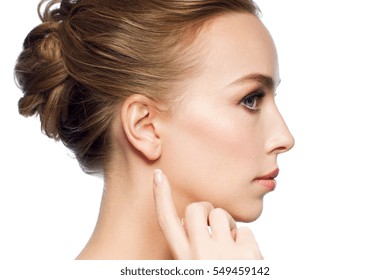 Health, People And Beauty Concept - Beautiful Young Woman Pointing Finger To Her Ear Over White Background