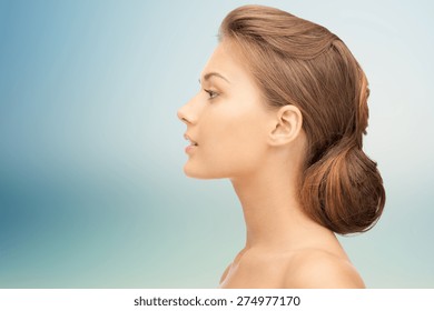 health, people, plastic surgery and beauty concept - beautiful young woman face over blue background
