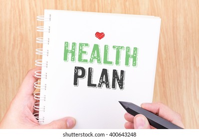 Health Plan Word On White Ring Binder Notebook With Hand Holding