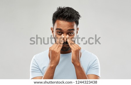 health problem and people concept - indian man rubbing nose over grey background Сток-фото © 