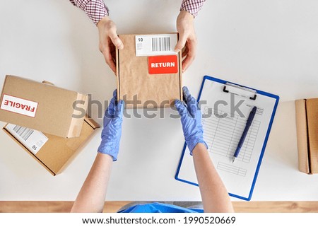health protection, delivery and mail service concept - customer making return of parcel or purchase and worker in protective gloves receiving box