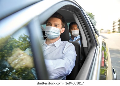 Health Protection, Safety And Pandemic Concept - Male Taxi Driver Wearing Face Protective Medical Mask Driving Car With Passenger