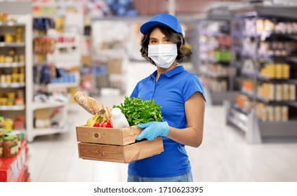 Health Protection, Safety And Pandemic Concept - Delivery Woman In Face Protective Medical Mask And Gloves Holding Wooden Box With Food Over Supermarket Or Grocery Store Background