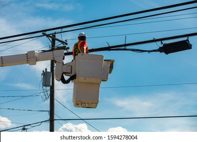 Health and safety in the construction and maintenance industry as a workman is seen from below in a cherry picker by a utility pole