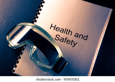 Health And Safety Document With Goggles In Toning