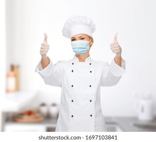 Health, Safety And Pandemic Concept - Female Chef Wearing Face Medical Mask And Gloves For Protection From Virus Disease Showing Thumbs Up