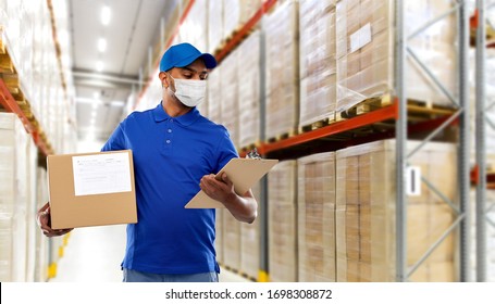 health, safety and pandemic concept - happy indian delivery man wearing face protective medical mask for protection from virus disease with parcel box and clipboard in uniform over grey background
