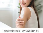 Health skin care, beauty smile asian young woman, girl  hand applying, putting moisturizer on her arm, shoulder after shower bath at home. Skin body cream moisturizing lotion, routine in the morning.