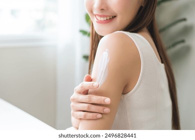 Health skin care, beauty smile asian young woman, girl  hand applying, putting moisturizer on her arm, shoulder after shower bath at home. Skin body cream moisturizing lotion, routine in the morning. - Powered by Shutterstock