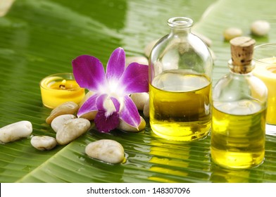 Health Spa With Massage Oil And Pink Orchid On Leaf