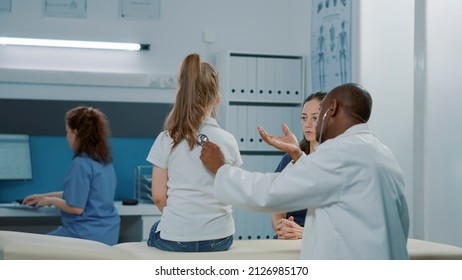 Health Specialist Using Stethoscope On Child To Measure Pulse And Heartbeat At Annual Checkup Visit. Male Doctor With Professional Instrument Consulting Little Girl To Treat Disease.