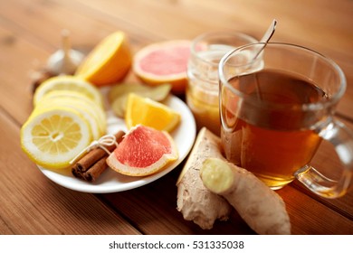 health, traditional medicine, folk remedy and ethnoscience concept - cup of ginger tea with honey, citrus and cinnamon on wooden background - Powered by Shutterstock