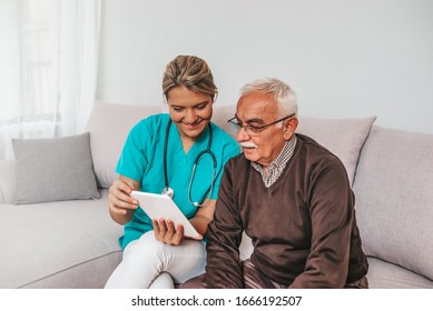 Health Visitor And A Senior Man During Home Visit. A Female Nurse Or A Doctor Showing Test Results On A Tablet. Senior Patient And Caregiver Using Tablet. I Found Some Entertainment For You