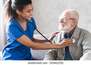 Health visitor and a senior man during home visit. Doctor checking heartbeat examining elder retired man at home. Seniors heart diseases, cardiology concept. - Powered by Shutterstock