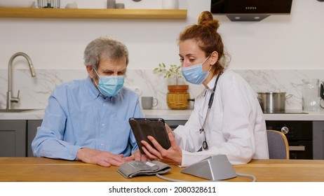 Health Visitor And A Senior Man During Home Visit. A Female Nurse Or A Doctor Examining A Man.