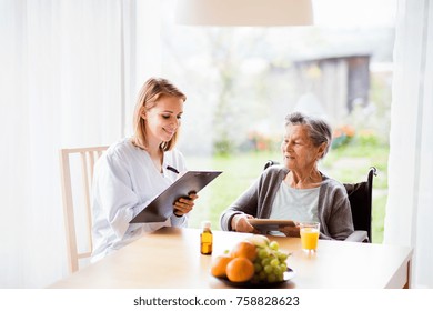 Health Visitor And A Senior Woman With Tablet.