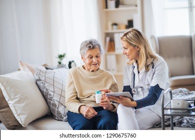 A health visitor with tablet explaining a senior woman how to take pills. - Powered by Shutterstock