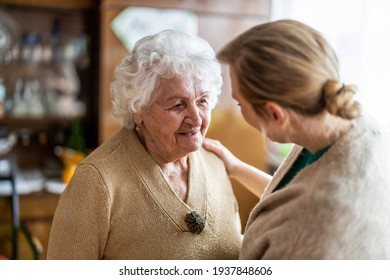 Health visitor talking to a senior woman during home visit
