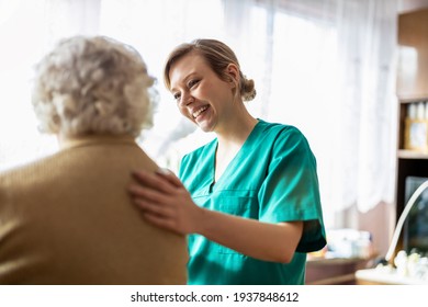 Health visitor talking to a senior woman during home visit
