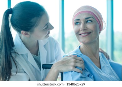 Health Visitors And Cancer Patients Women During The Home Visit. Caring Female Nurse Talk To Disabled Patient In Hospital. Professional Young Medical Doctor Hugging Patient. Health, Insurance Concept.