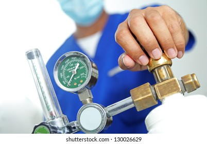Health worker checking an oxygen tank.