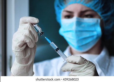 health worker dials the vaccine into a syringe - Powered by Shutterstock