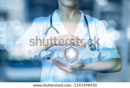 Health worker shows a gesture of protection of the internal organs on blurred background.