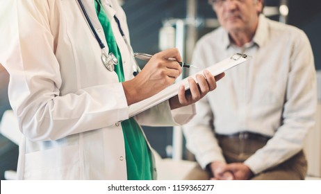 Health worker taking notes from senior male patient