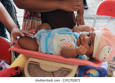 A Health Worker Is Weighing A Baby's Weight At The Surabaya Indonesia Public Health Center On May 21, 2014