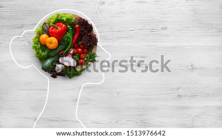 Health in your brain. Fresh vegetables in woman head symbolizing health nutrition on gray background, panorama, copy space