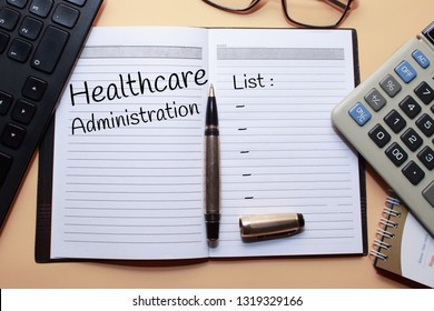 Healthcare Administration Text Write On Notebook With A Computer Keyboard, Glasses, Pens, Calculators On The Desk. Business Concept