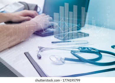 Healthcare business medical concept. Virtual charts and diagrams on the background of the doctor s hands with a stethoscope, clip board and laptop - Powered by Shutterstock