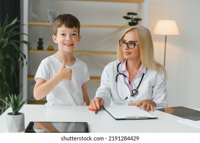 Healthcare For Children: Little Boy Talking To Doctor During Visit To Hospital