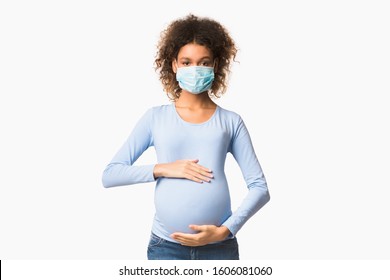 Healthcare concept. Afro pregnant woman in protective mask against flu and viruses, white background