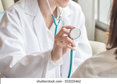 Healthcare Concept With Cardiologist Doctor Examining Woman Patient's Heart Health Diagnosing Cardiovascular Disease Illness Symptom Checkup Using Stethoscope In Medical Clinic Or Hospital