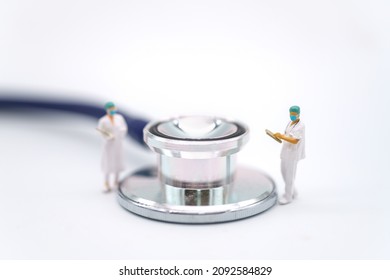 Healthcare Concept. Closeup Of Two Doctor Miniature Figureห With Patient File Standing With Stethoscope On White Background.