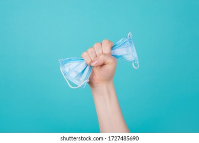 Healthcare concept. Cropped photo of woman holding a mask in fist raising up in air isolated on blue background - Powered by Shutterstock