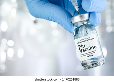 Healthcare concept with a hand in blue medical gloves holding Flu, Influenza, vaccine vial - Shutterstock ID 1470251888