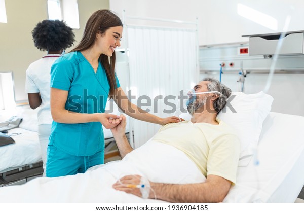 Healthcare concept of professional doctor consulting\
and comforting elderly patient in hospital bed or counsel diagnosis\
health. Medical doctor or nurse holding senior patient hands and\
comforting him