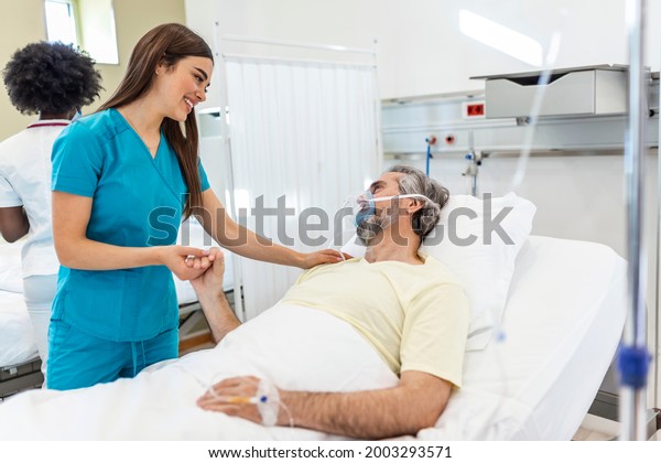 Healthcare\
concept of professional doctor consulting and comforting elderly\
patient in hospital bed or counsel diagnosis health. Medical doctor\
or nurse holding senior patient\'s\
hands