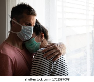 Healthcare Concept. Sad Couple In Masks Posing Near Window At Home