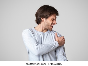 Healthcare Concept. Unhappy Man Suffering From Shoulder Pain, Free Space