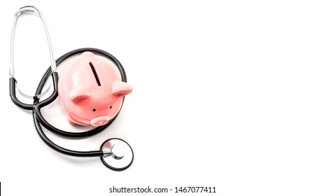 Healthcare cost and the high price of quality health care insurance concept theme with a stethoscope and a pink piggy bank isolated on white background with copy space