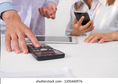 Healthcare Costs And Fees Health Concept.Hand Of Smart Doctor Used A Calculator For Medical Costs At Modern Hospital In Sun Light,warm Colours Sun Light