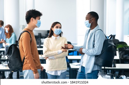 Healthcare, Education, Lifestyle And People Concept. Group Of Smiling Diverse International Students Wearing Protective Medical Masks And Talking, Standing In Lecture Hall At The University