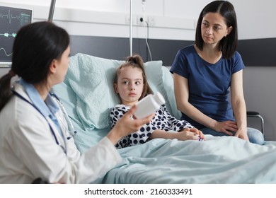 Healthcare facility clinic pediatric expert recommending ill patient girl right medicine for disease remission. Hospital pediatrist specialist talking with attentive mother about illness treatment.