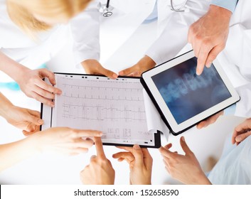 Healthcare, Hospital And Medical Concept - Group Of Doctors Looking At X-ray On Tablet Pc