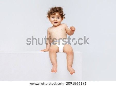 Healthcare, infant. New generation. Portrait of little cute toddler boy, baby in diaper sitting isolated over white studio background. Concept of childhood, motherhood, life, birth. Copy space for ad