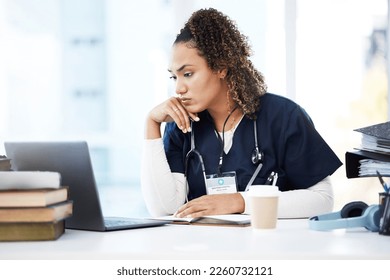 Healthcare, laptop and research with a woman nurse reading information in a hospital for diagnosis. Medical, insurance and education with a female med student working in a clinic for data analysis - Powered by Shutterstock