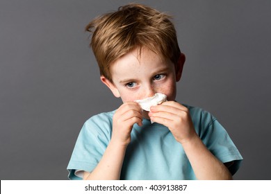 Healthcare Learning - Sick Young Kid With Red Hair And Freckles Using A Tissue After A Cold, Rhinitis Or Spring Allergies, Grey Background Studio